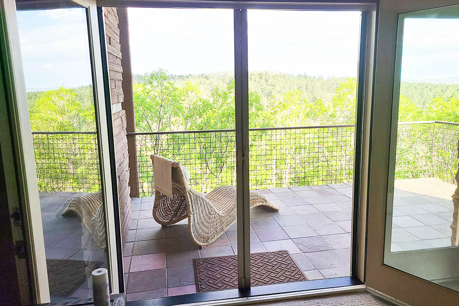 A dark retractable screen pulled partially in front of a home's black double door.