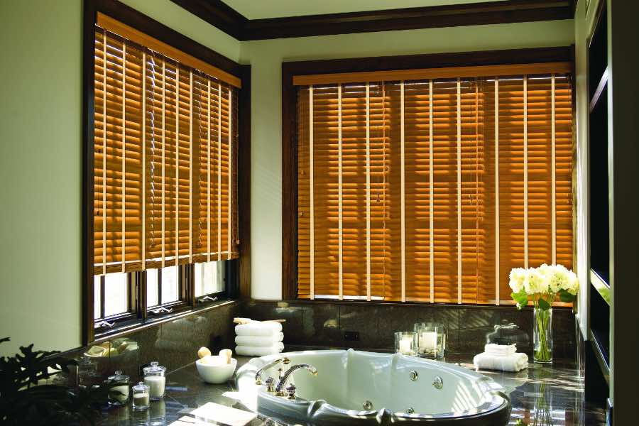 Premium quality blinds are always a stylish accent in your San Diego home. Brown wood blinds on large windows in a green bathroom