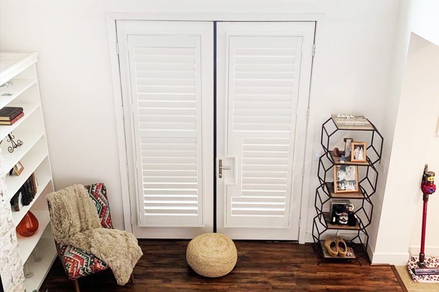 White Polywood shutters are the perfect window treatments for French patio doors, as they provide energy savings, light control, and privacy. White plantation shutter customized for French door with cutout for handle.