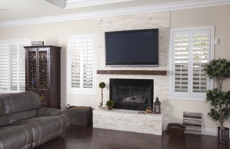 White plantation shutters in a San Diego living room with dark hardwood floors. White plantation shutters in a San Diego living room with dark hardwood floors.