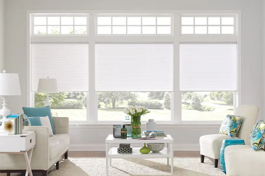 Insulating cellular shades can help keep cold air and hot UV rays from entering your San Diego home. White cellular shades on windows in a white living room